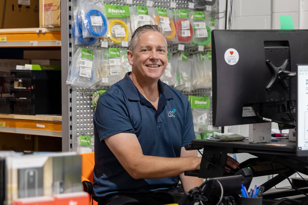 Happy LSC employee sitting at desk